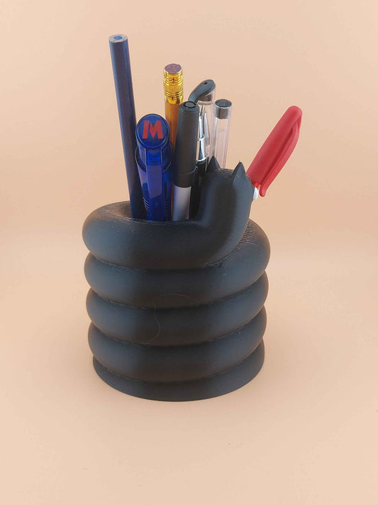 Straight view of the coiled, black stationery holder, packed with tools.