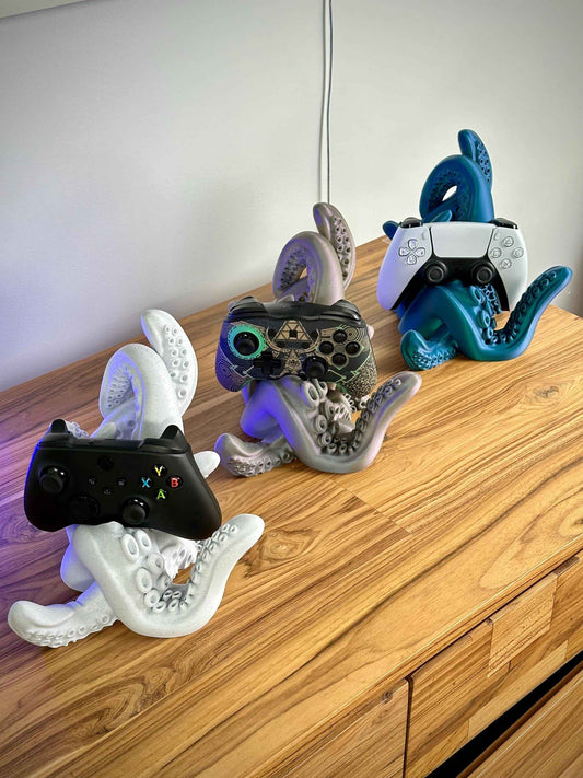 Tentacle controller holder holding a PS5, Switch pro and Xbox controller on a wooden desk.