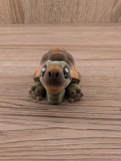 Front view of the mini turtle fidget toy with large eyes and green legs