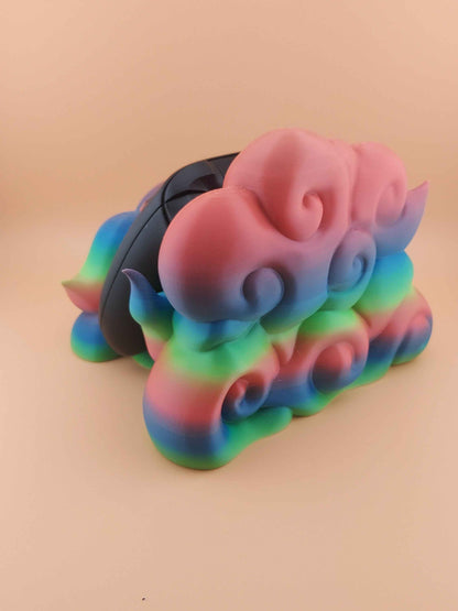 Left profile of a black controller obscured by large, coiled, smooth pink and blue gradient plastic cloud forms.