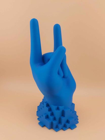 Frontal view of the matte blue hand stand making the "Rock On" sign, resting on its bright blue pixelated base.