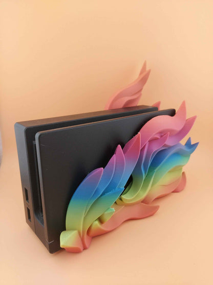 Elevated side profile of the black dock, highlighting the layered flow of the matte rainbow wing/flame decoration.