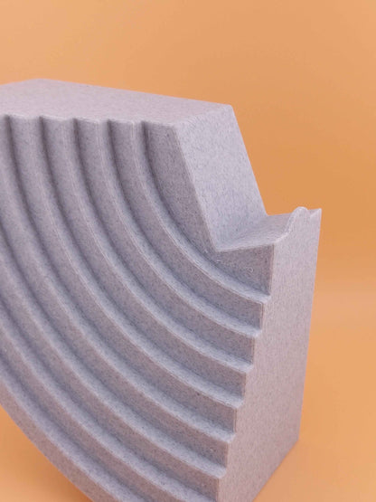Close up of the speckled light grey stand showing the coarse texture and deep curved steps.