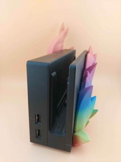 Close up of the black console dock showing USB ports, framed by bright, spiky rainbow flames on the right side.