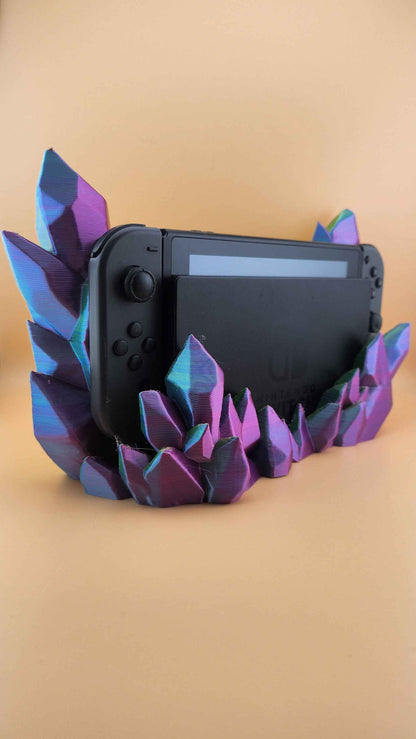 Crystal cluster stand in shifting purple and teal hues, holding a black Nintendo Switch console.