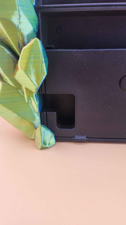 Close up of the console dock's recessed slot surrounded by vivid shifting green, gold, and blue crystal formations.