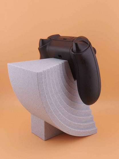 High-angle view of the black controller resting on the speckled grey stand with dramatic curved riser steps.
