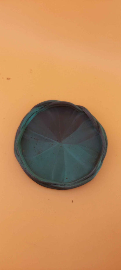 Centred overhead shot of the planter's teal and dark blue circular base with a geometric faceted centre.