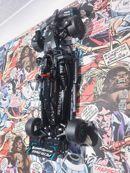 Vertical mount of a black Lego F1 race car model, displayed on colourful Star Wars comic book wallpaper.