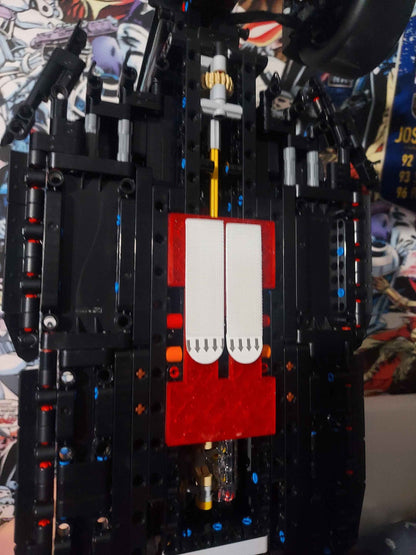 Detailed view of the black Lego chassis and internal workings, with a bright red and white mounting bracket secured.