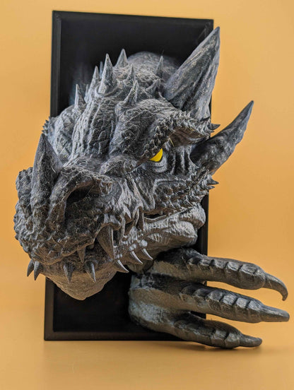 Close-up side view of the menacing grey dragon head. Sharp teeth and spikes cover the snout, with glaring yellow eyes.