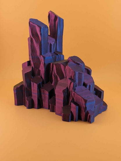 Side profile of the rocky controller stand, showing tall peaks and shifting colours of vibrant magenta and deep indigo blue.