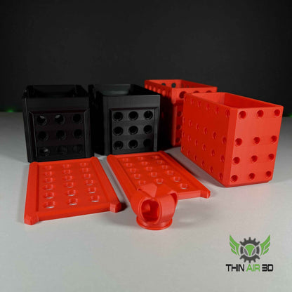 Disassembled components showing two matte black containers, two bright red containers, and two red lids with a central handle.