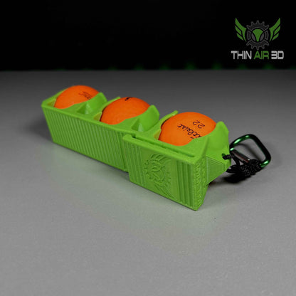 Steep diagonal view of the lime green three-ball carrier, focusing on the carabiner and side detailing.