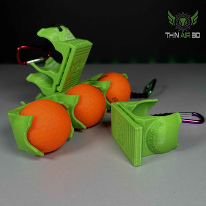 Wide angle group shot of several lime green golf ball carriers in single and double configurations, with orange golf balls.