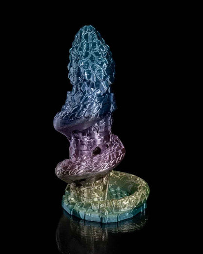 Back view of the serpentine tower sculpture, revealing the full rainbow iridescent finish against a black background.