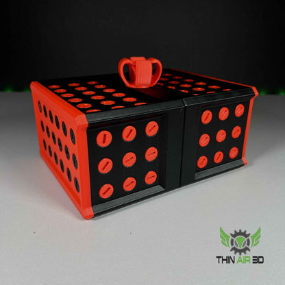 Black and matte red modular storage system with patterned side holes and a central red loop handle.
