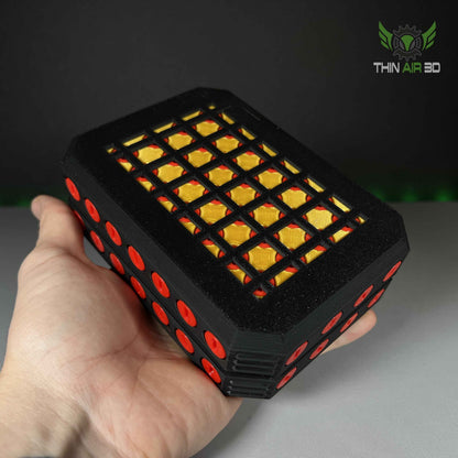 Close side profile of the black module held in a hand. The meshed top reveals a vivid yellow, quilted interior lining.