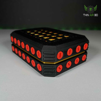 Close low-angle view of two stacked black modules, accented with rows of small, vivid red oval inserts.