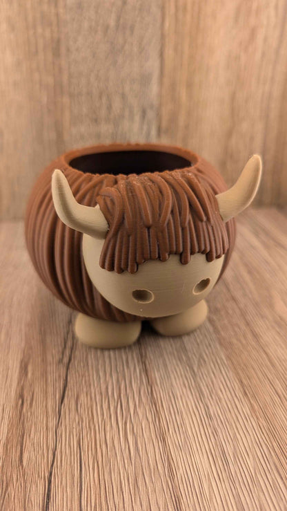 Angled view of the squat, round brown cow planter, emphasising its textured hair and cute tan face.