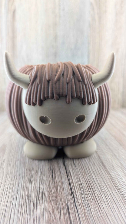 Straight front perspective of the brown Highland Cow planter with prominent tan horns and wide, stable feet.