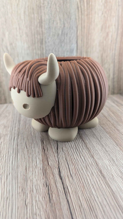Three-quarter side view showcasing the brown ribbed texture of the Highland Cow's body and tan horns.