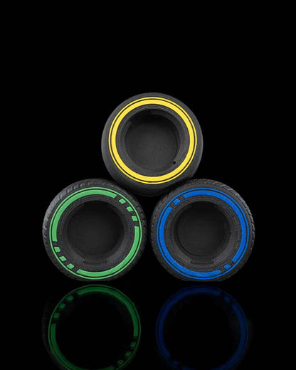 Close up of three wheel attachments stacked in a pyramid: yellow, green, and blue rims on dark treaded tyres.