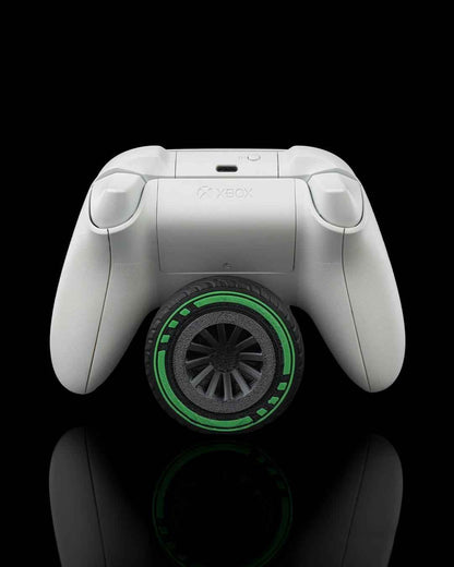 Rear view of the white Xbox controller, centred over a dark treaded tyre featuring a neon green ring.