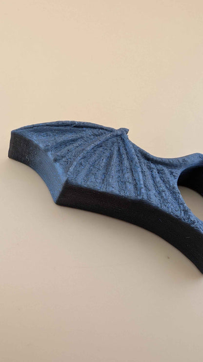 Extreme close up, side view of the highly textured, matte dark grey bat wing surface and membrane structure.