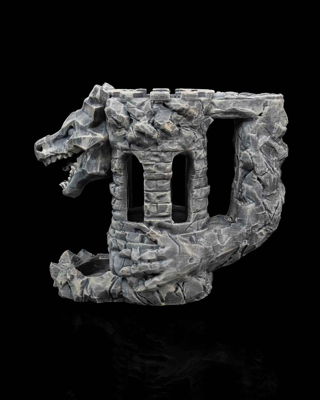 Detailed side profile of the grey stone tower dice roller structure. The dragon's head projects dramatically from the left.