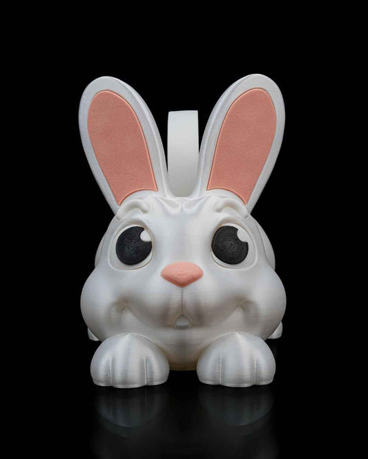 Direct frontal close-up of the shimmering white bunny basket face. Features black eyes, a pink nose, and front paws.