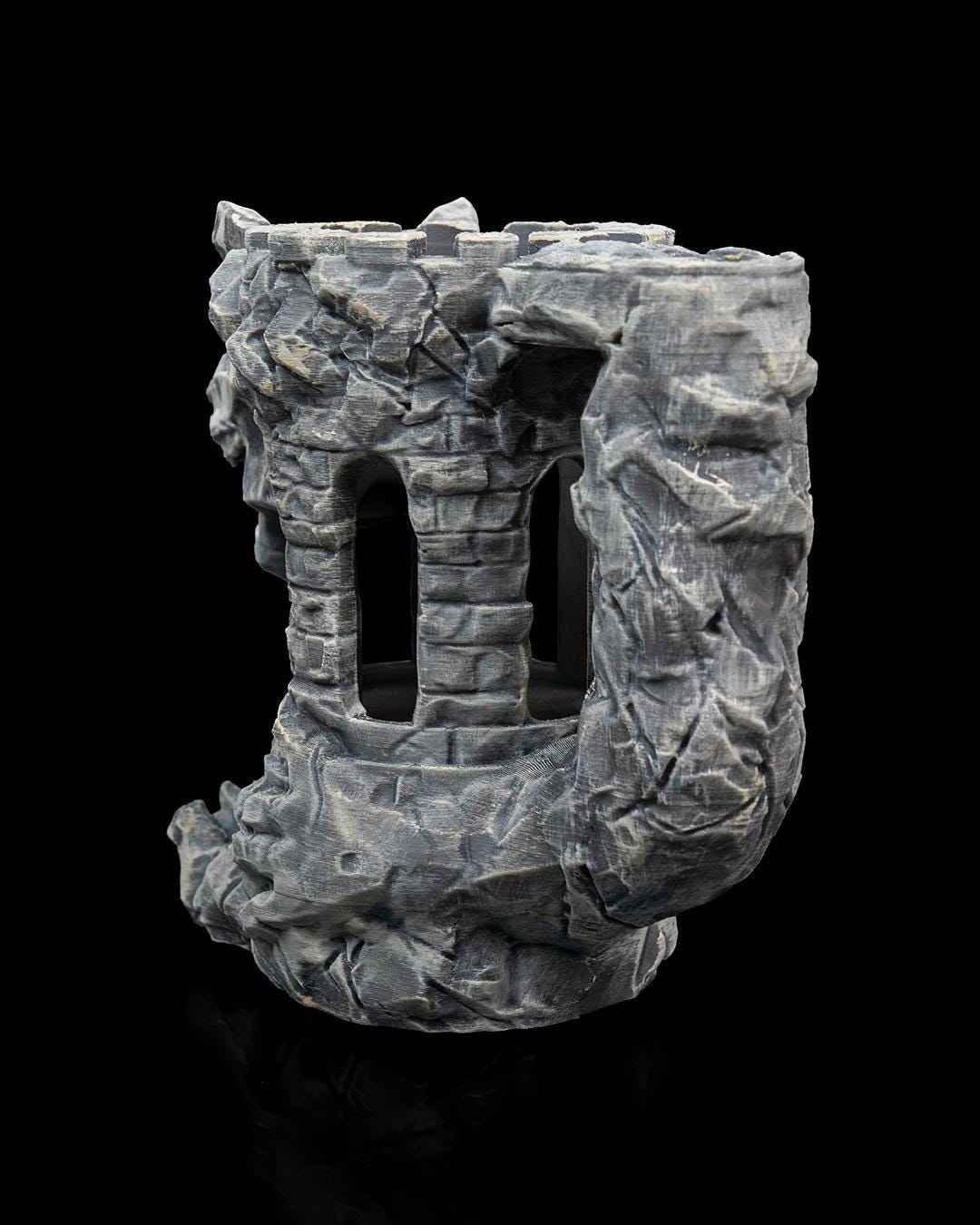 Side view of the grey stone tower dice roller. Textured rock formations surround brick arch windows on a black background.