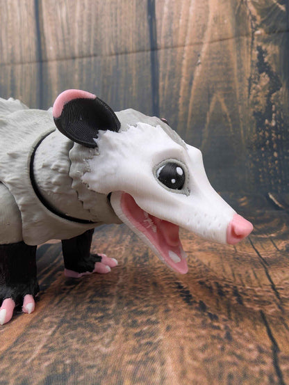 Close side profile of the opossum toy's white face and grey fur texture, showing the detailed open mouth.