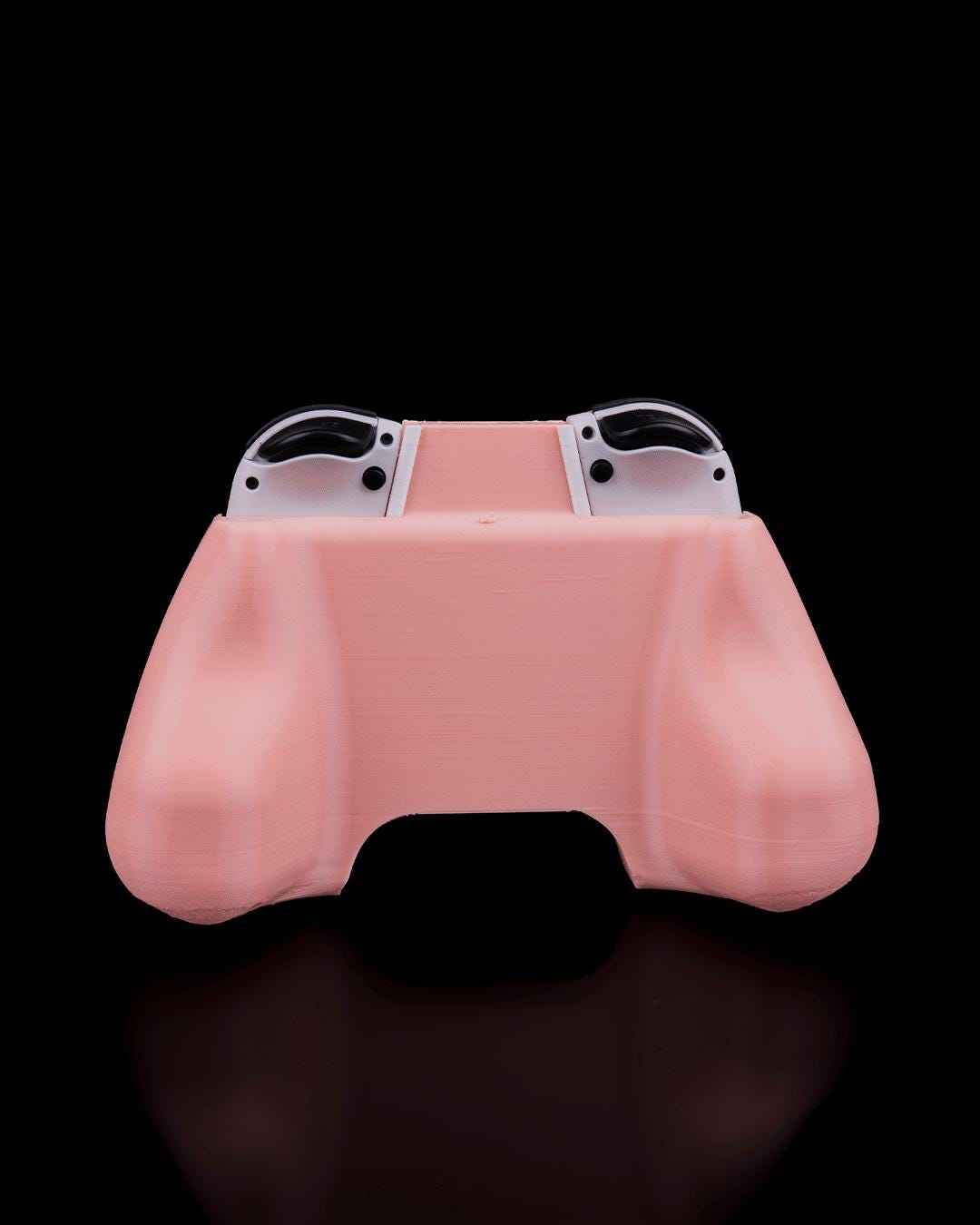 Back view of the pale pink ergonomic controller grip, showing the smooth, rounded handles and the tops of the white Joy-Cons.