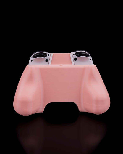 Back view of the pale pink ergonomic controller grip, showing the smooth, rounded handles and the tops of the white Joy-Cons.