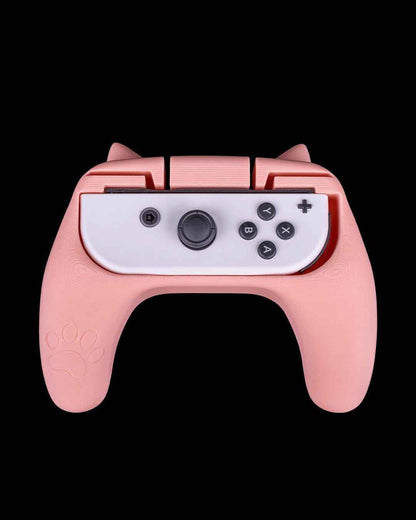 Straight-on view of the pink controller grip featuring white cat ears and a large white paw print decal.