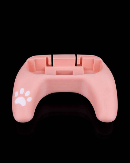 Rear view of the empty, U-shaped soft pink controller grip shell. White paw print visible on the left side.