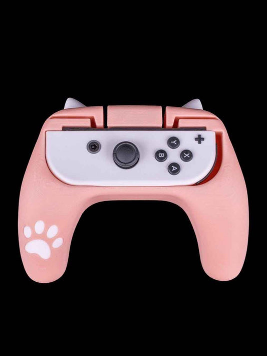 Front view of a soft pink controller grip with white cat ears and a paw print decal, holding a white joycon.