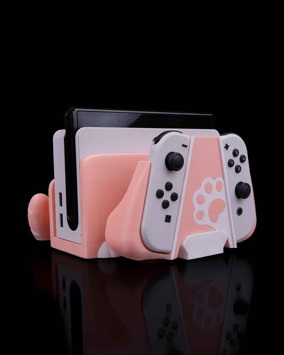 Matte peach cat dock, with white details, holding a Nintendo Switch and Joy-Cons. White paw print visible.