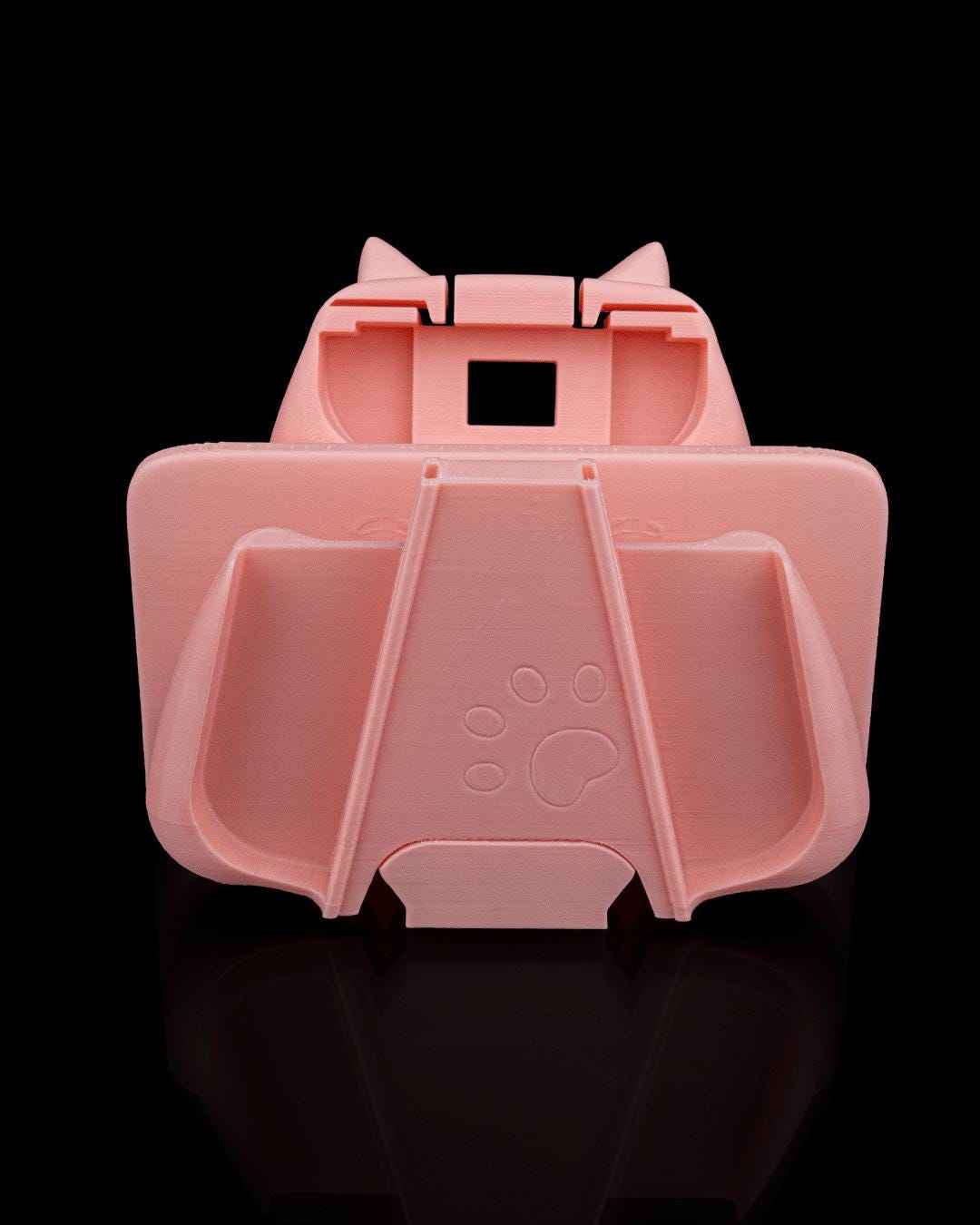 Rear, bottom-up view of the matte peach controller holder section, showing an embossed paw print detail.