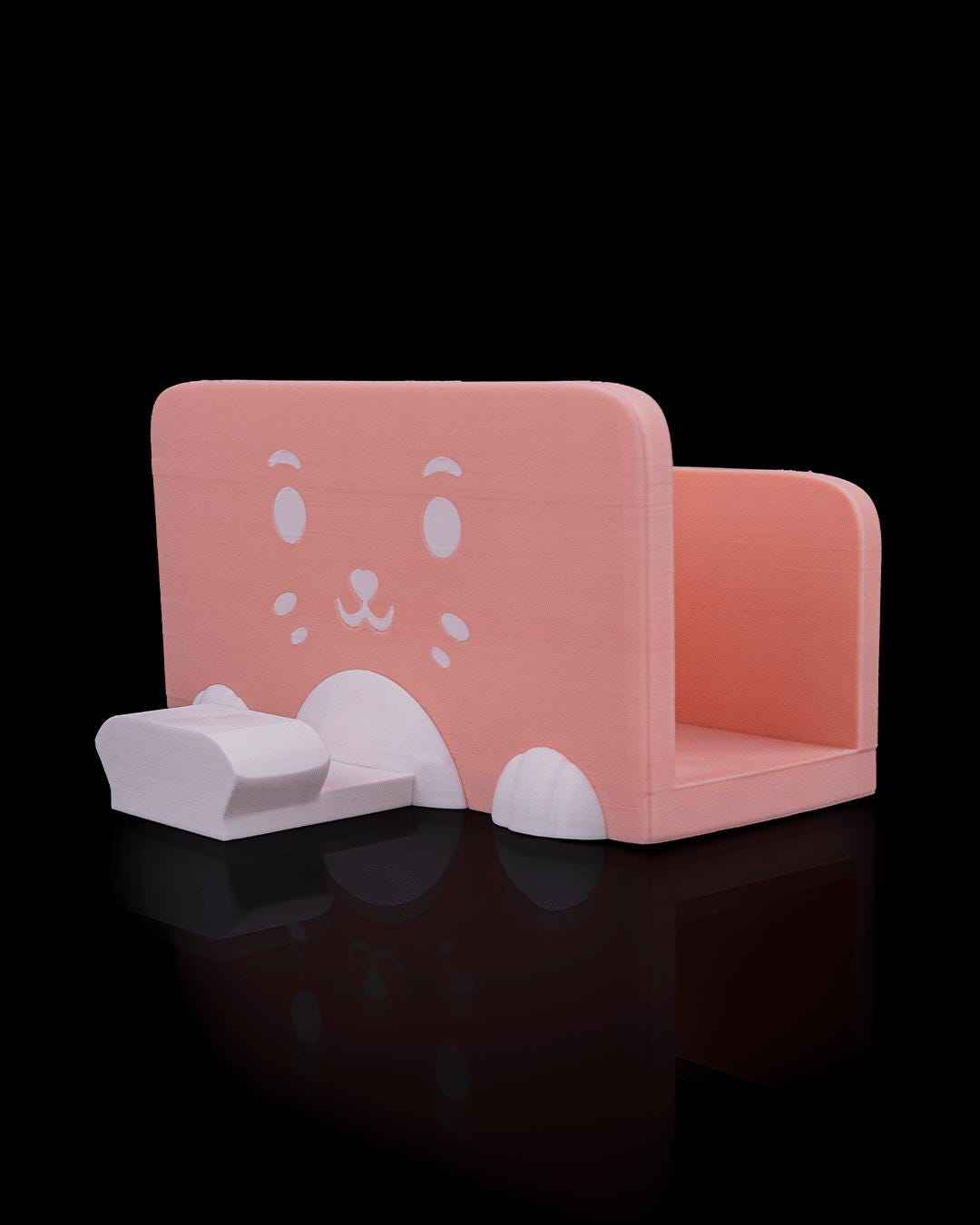 Side view of the empty matte peach dock base. A cute white cartoon cat face decal is prominent on the surface.