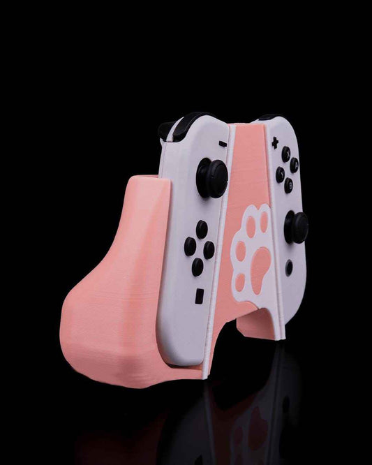 Angled view of the pale pink Joy-Con grip highlighting the ergonomic handle shape and central white panel with a paw print.