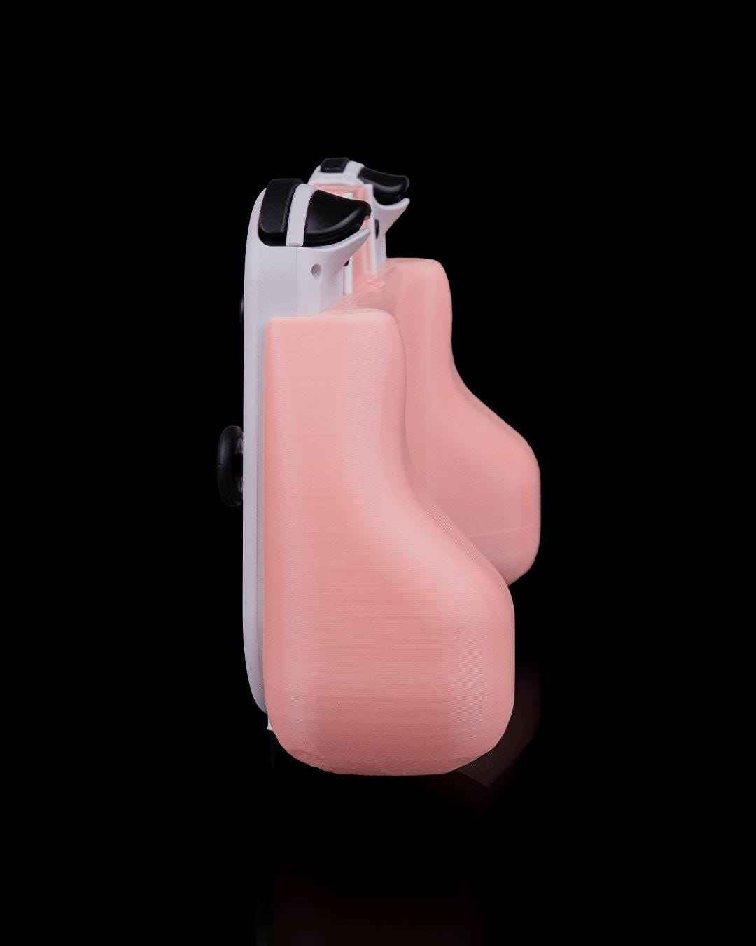 Strict side profile showing the thick, rounded depth of the pale pink ergonomic comfort handles attached to a white controller.