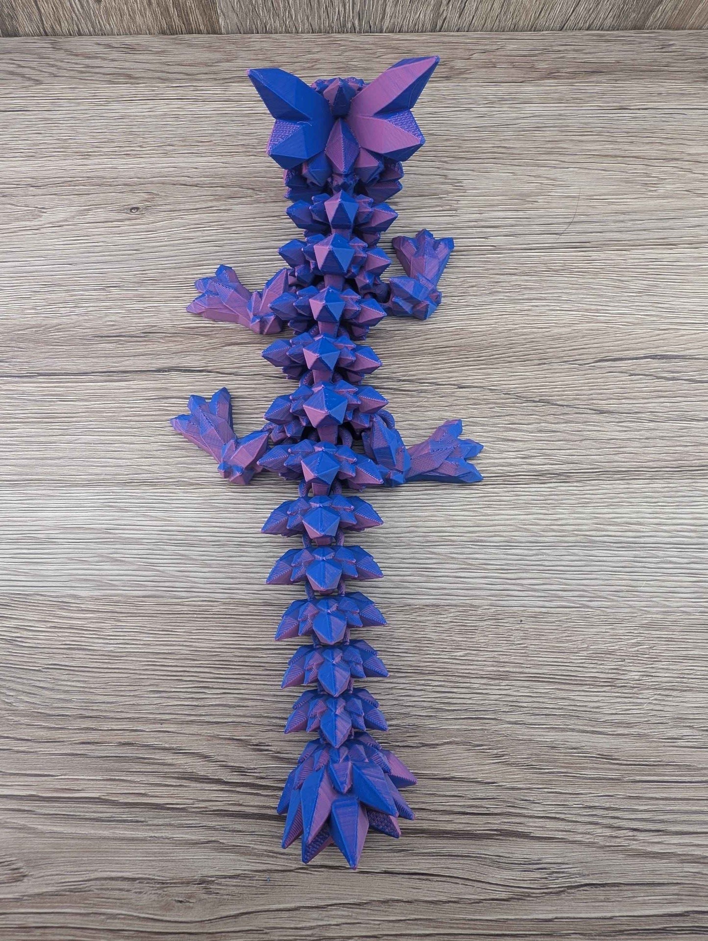 Top-down view of the articulated blue and purple crystal dragon, showcasing the full length and complex spiky texture.