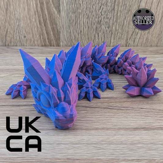 Articulated crystal dragon figure in shifting purple and blue colors, displayed on a wood grain surface.