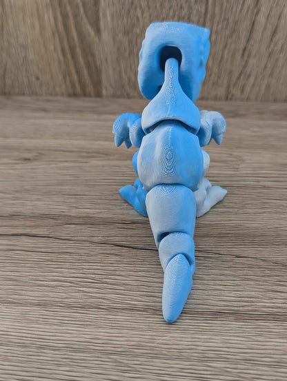 Back view of the matte blue flexible dinosaur showing the spine and segmented tail extending downward.