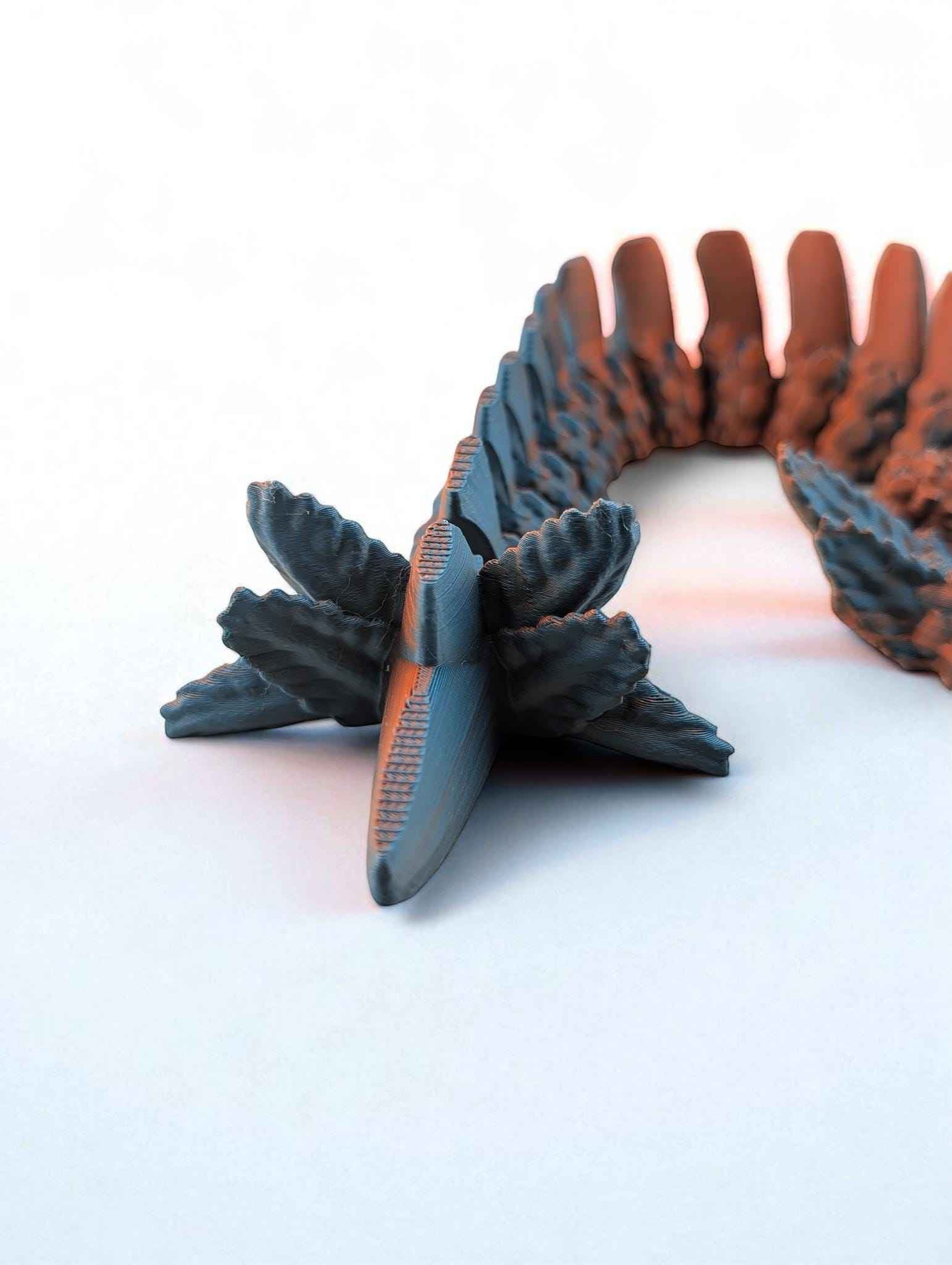 Close up of the articulated tail segment forming an arch, showing the textured blue exterior and orange interior.