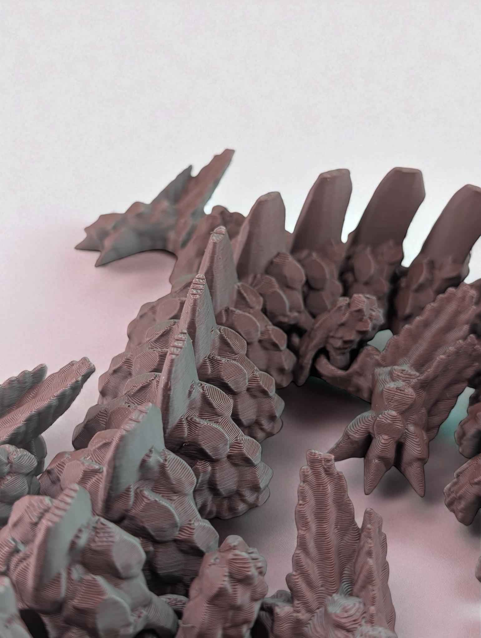 Side view focusing on the spine: large dorsal fins rise from the articulated body's rocky, jagged texture.