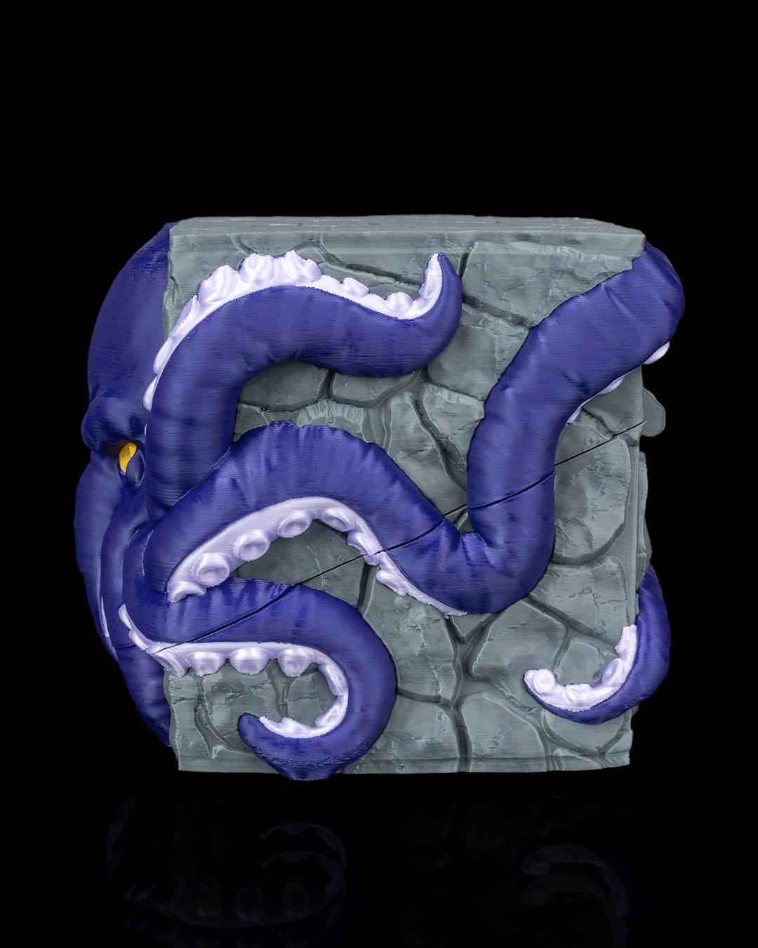 Back side view of the gray stone container, wrapped with thick, coiled purple octopus tentacles and white suckers.