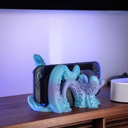 Matte blue and purple colour-shift kraken stand holding a black console, detailed with suction cups.
